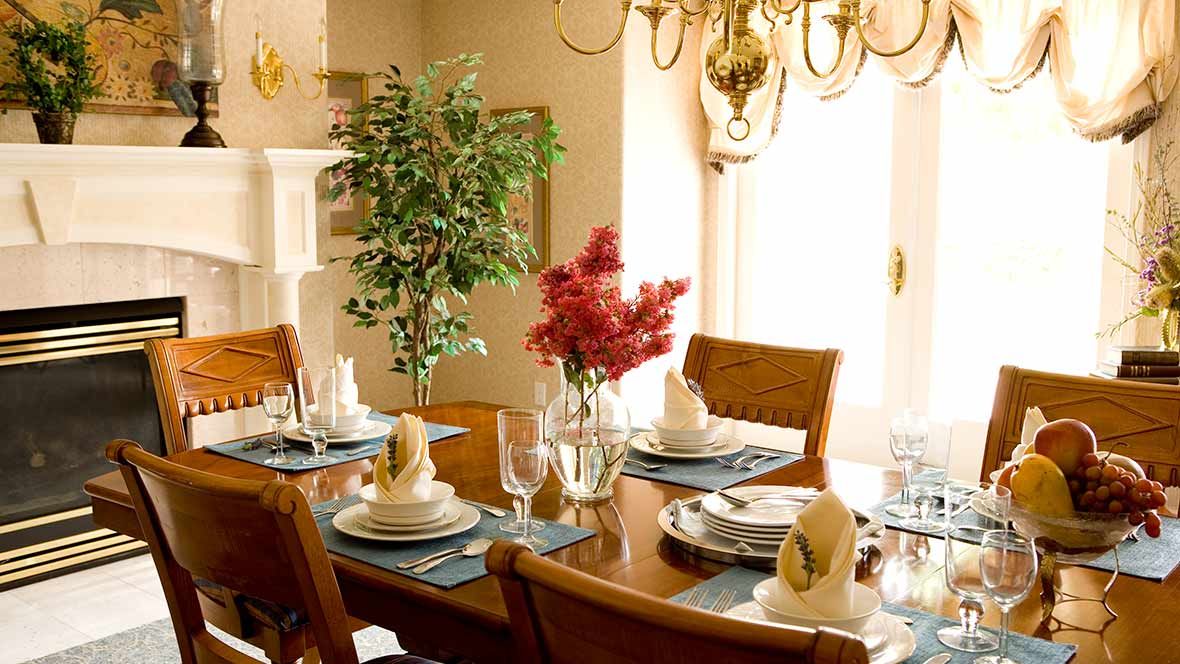 A beautifully set dining table with elegant place settings and a floral centerpiece.