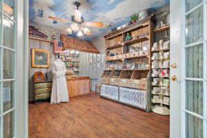 A cozy vintage-themed store interior with wooden floors and shelves displaying various products.