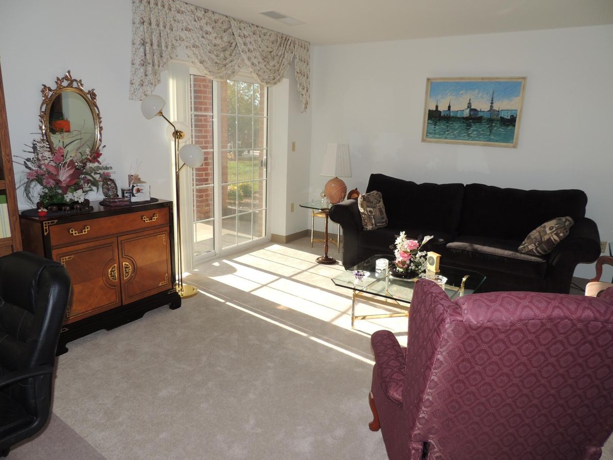 A cozy living room with a sofa, armchair, and elegant decor.