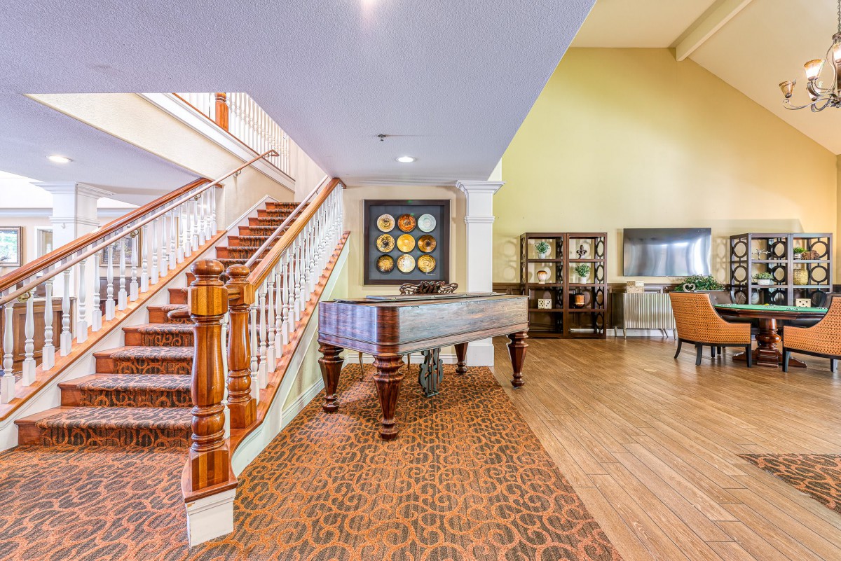 A cozy lounge area featuring a foosball table, staircase, and decorative artwork.