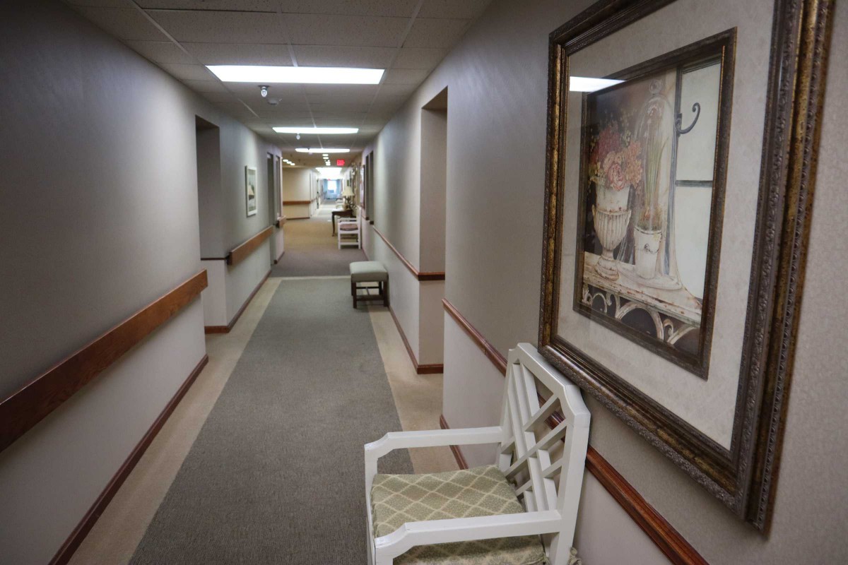 A hallway with seating and artwork on the walls.