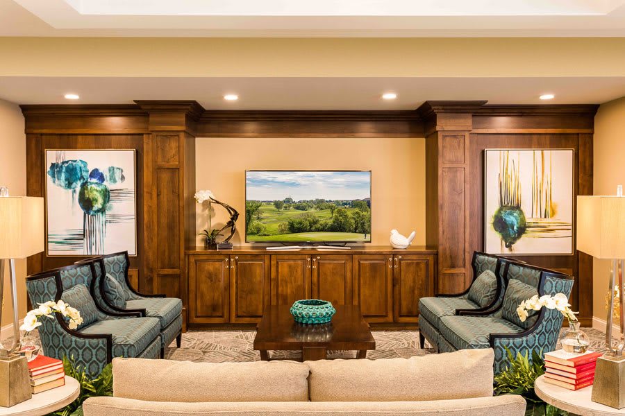 A well-decorated living room with wooden cabinetry, a television, and comfortable seating.