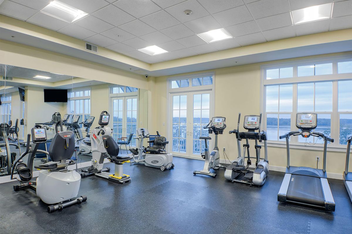 A spacious gym equipped with various cardio machines, including treadmills and stationary bikes.