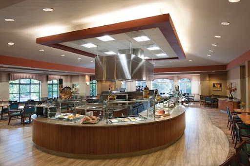 A modern cafeteria featuring a self-service food station and ample seating.