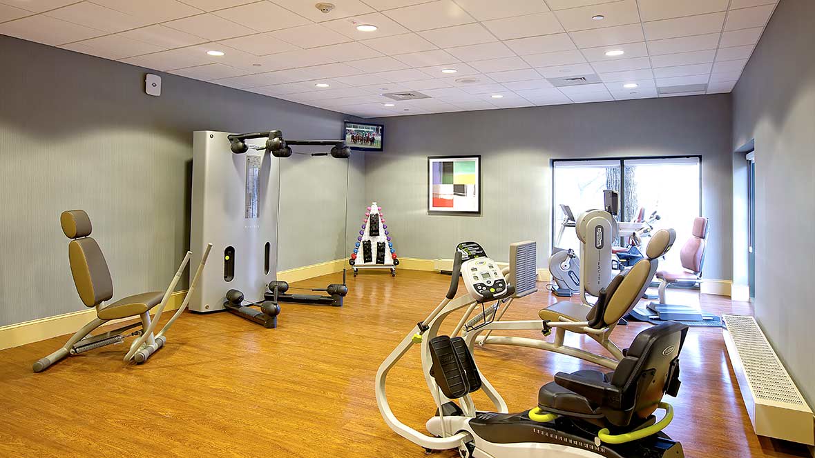 A modern gym with various exercise equipment and workout machines.