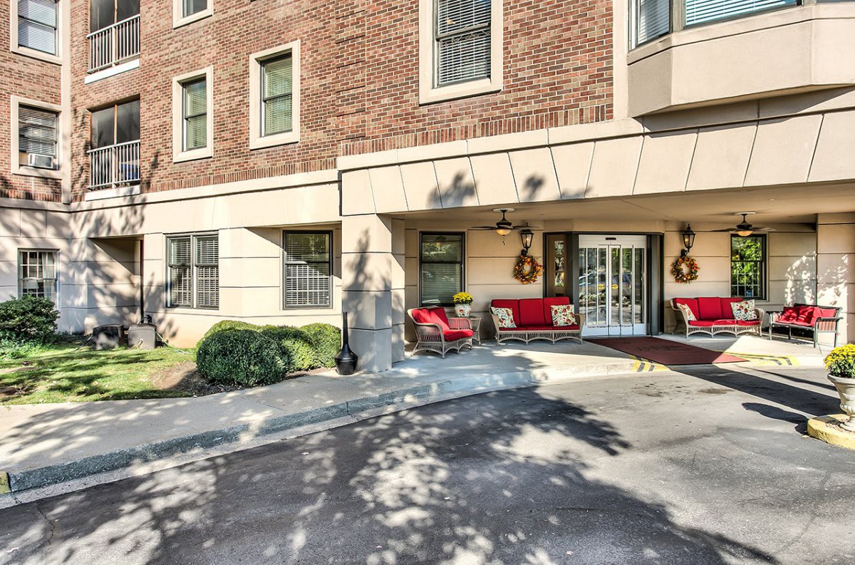 The entrance of a building with outdoor seating and decorative elements.