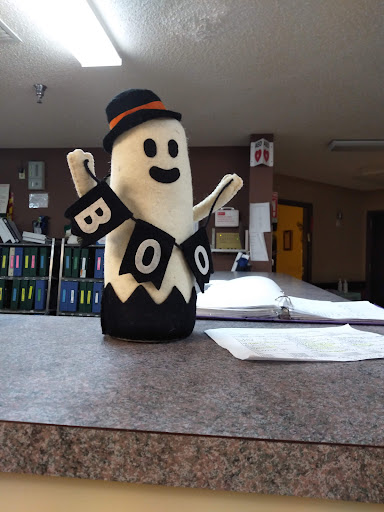 A cheerful ghost decoration with a 'BOO' banner, perfect for Halloween spirit.