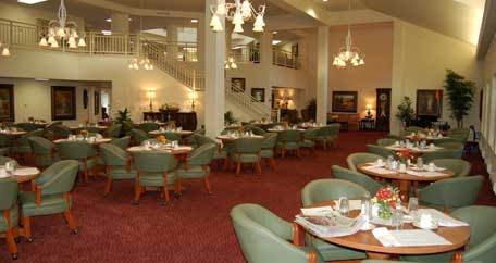 An elegant restaurant interior with neatly arranged tables and chairs under warm lighting.