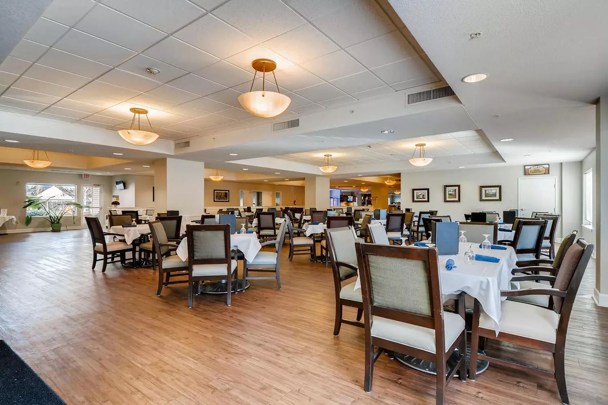 A spacious and elegantly designed dining area with neatly arranged tables and chairs.