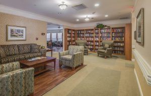 A cozy library reading room with bookshelves and comfortable seating.