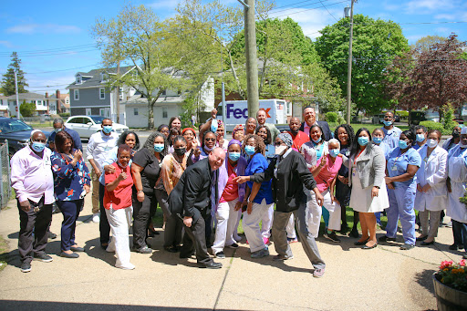 A diverse group of individuals gathered outdoors for a celebratory event, all wearing masks.
