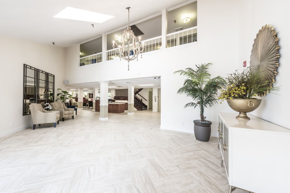 A bright and spacious modern lobby with elegant furnishings and decorative plants.