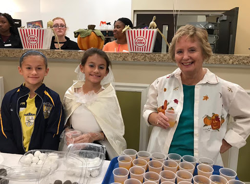A fun community event featuring children in costumes, enjoying treats together.
