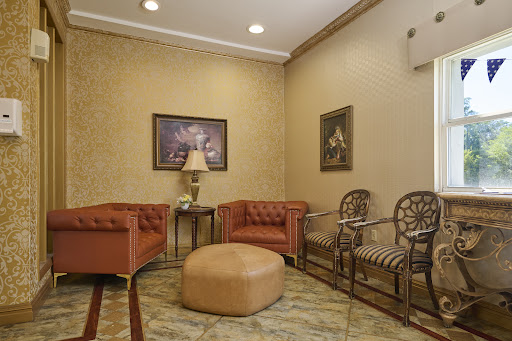 A cozy waiting area featuring elegant furniture, artwork, and a warm color palette.