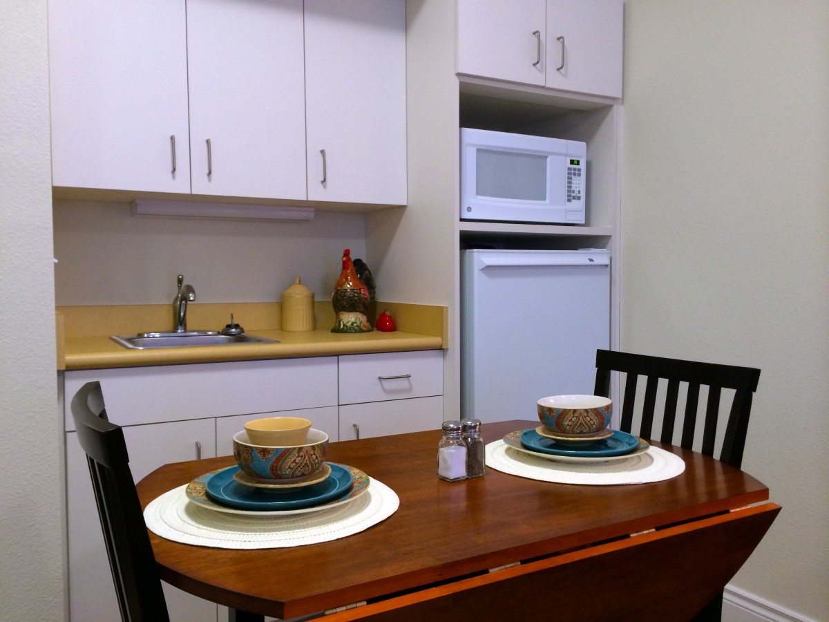 A cozy kitchen setup with a dining table arranged for two.
