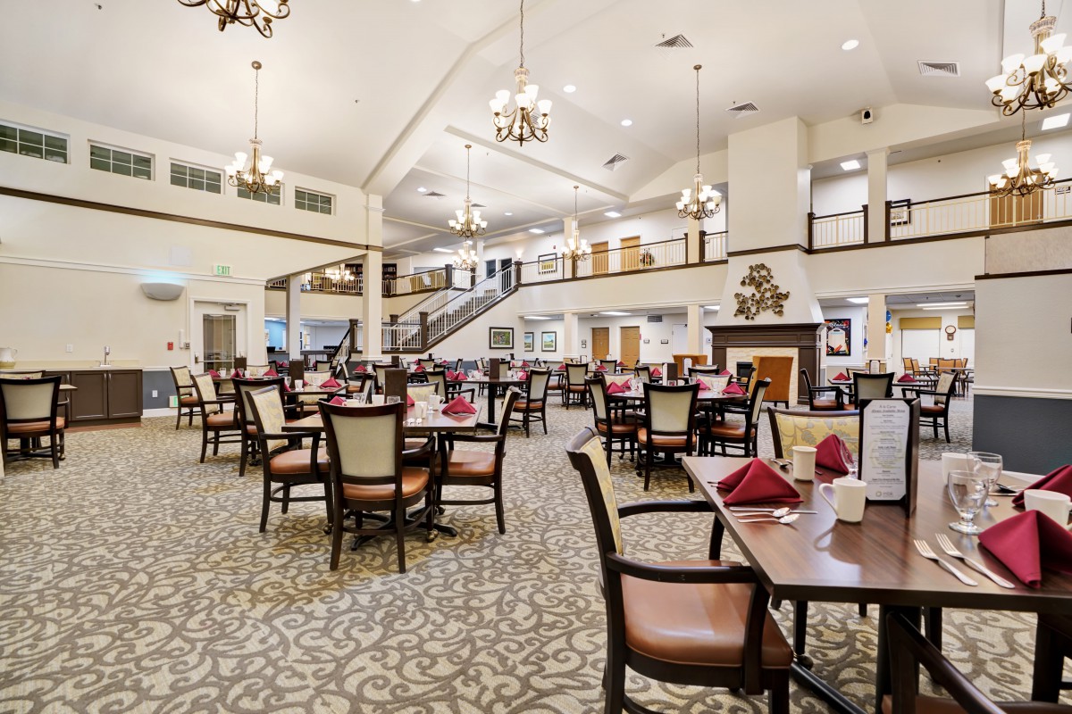 A spacious and elegantly designed dining room with neatly arranged tables and decorative lighting.