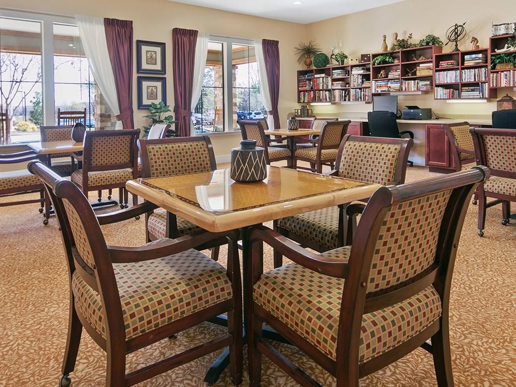 A cozy dining room setup with tables and chairs, featuring an adjacent office area.
