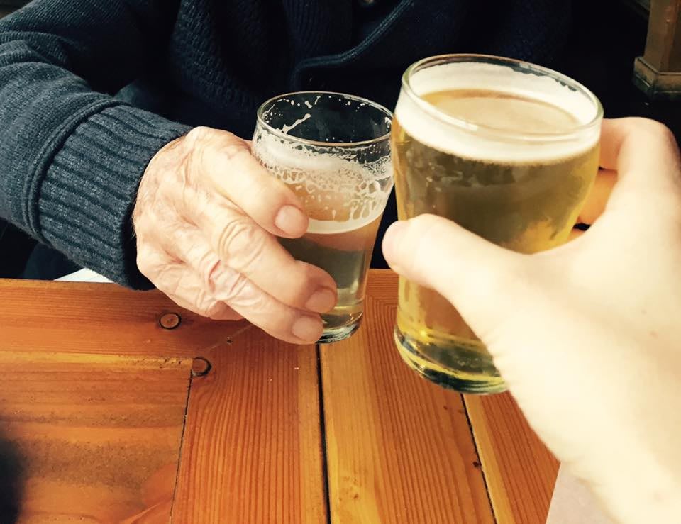 Two people clinking glasses of beer in a celebratory toast.