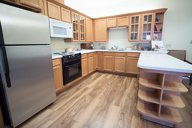 A modern kitchen with wooden cabinets, stainless steel appliances, a microwave, oven, and refrigerator.