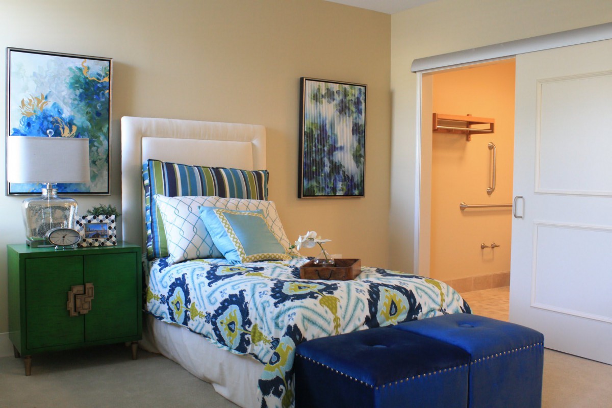 A modern bedroom with colorful bedding and stylish decor.