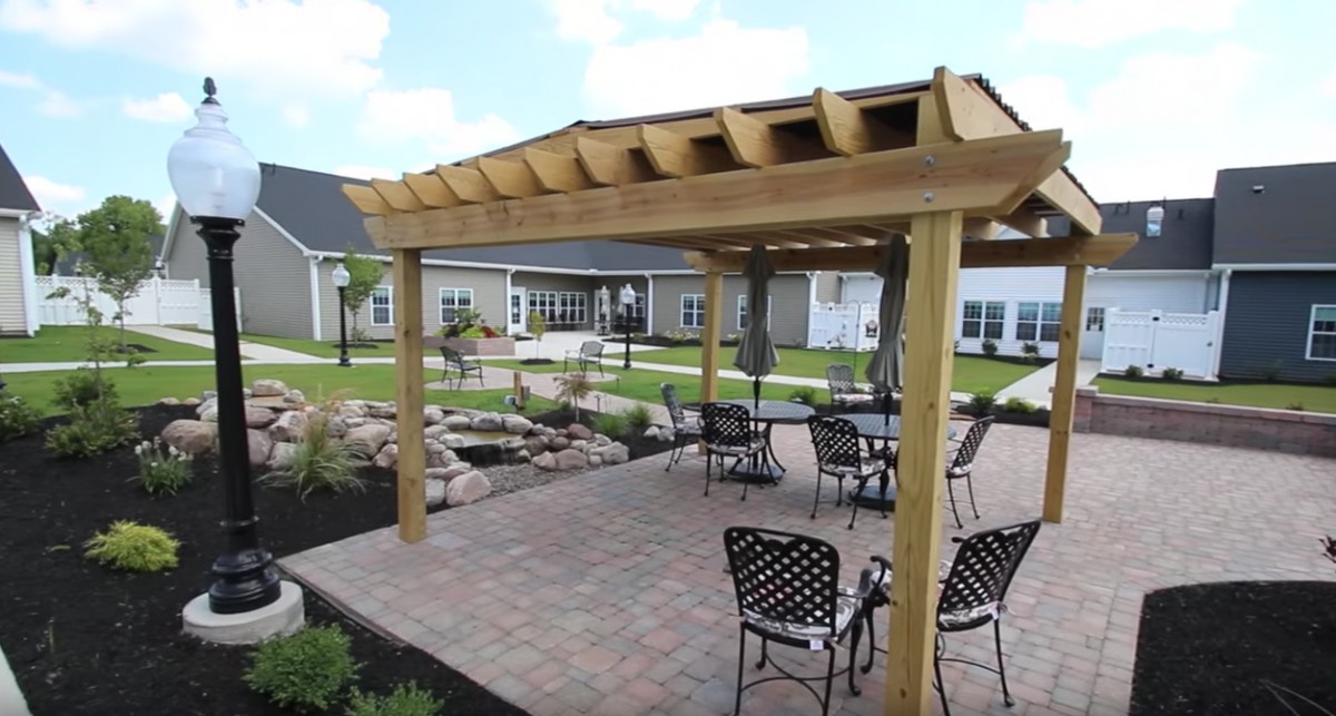 A beautifully landscaped patio with a pergola and outdoor seating area.