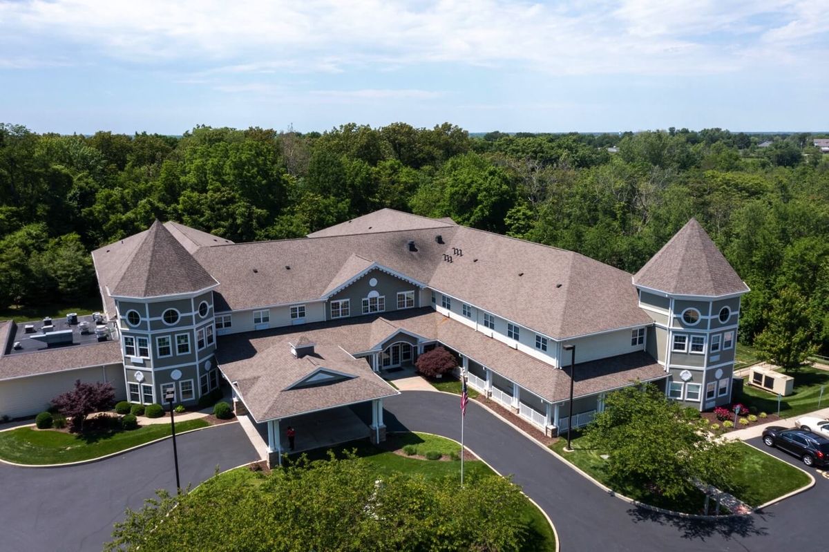 Aerial view of a large residential building surrounded by lush greenery.
