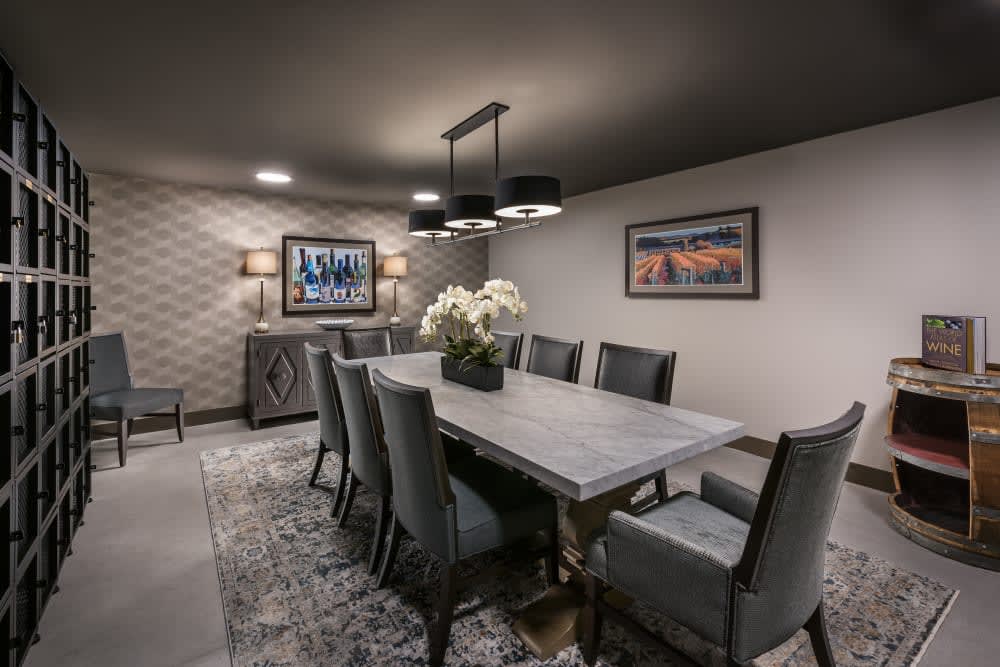 A modern dining room with a large table, elegant chairs, and stylish lighting.