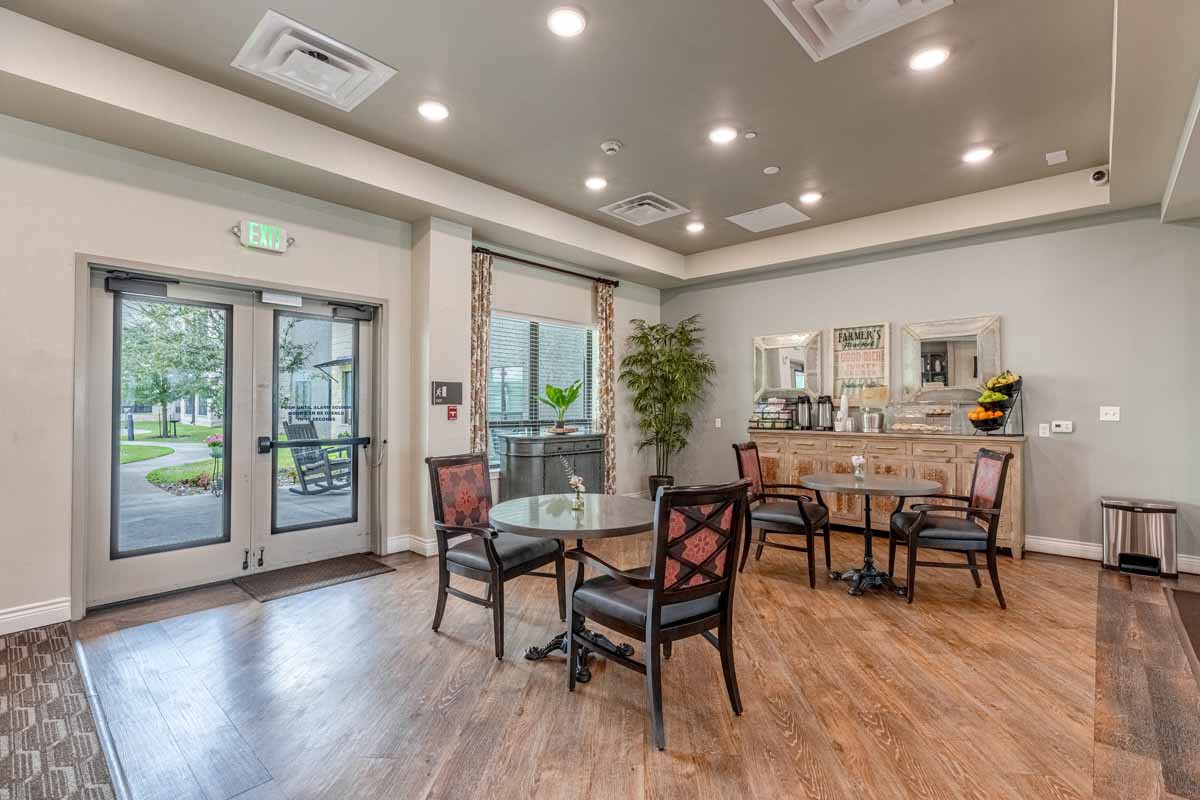 A modern dining area with tables and chairs, featuring elegant decor and ample lighting.