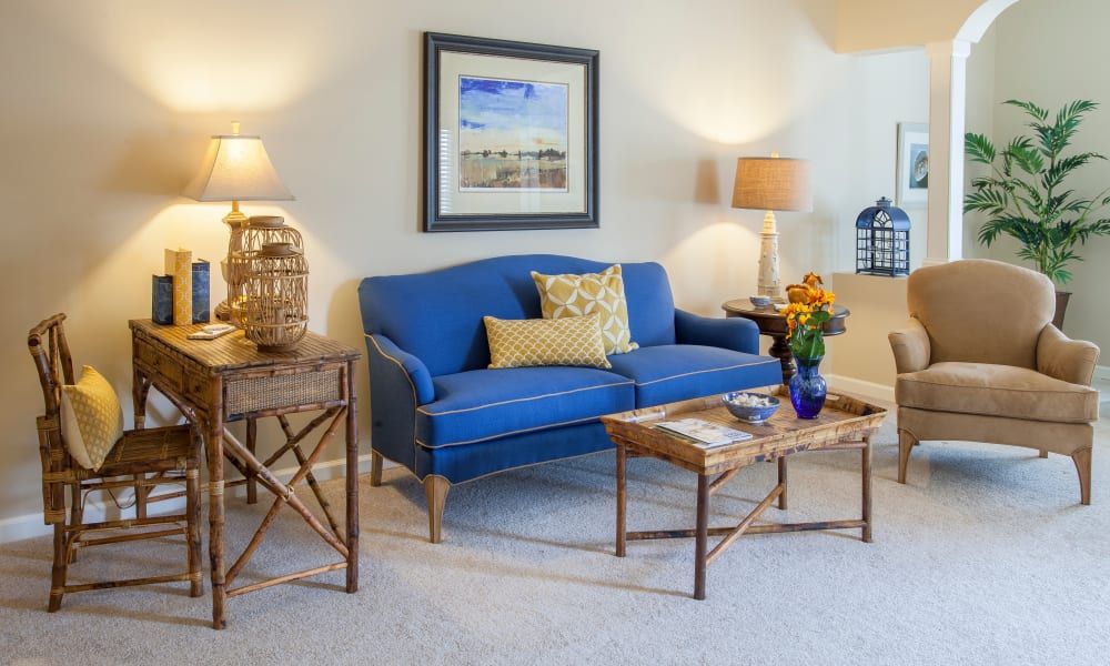 A cozy living room with a blue sofa and stylish decor.