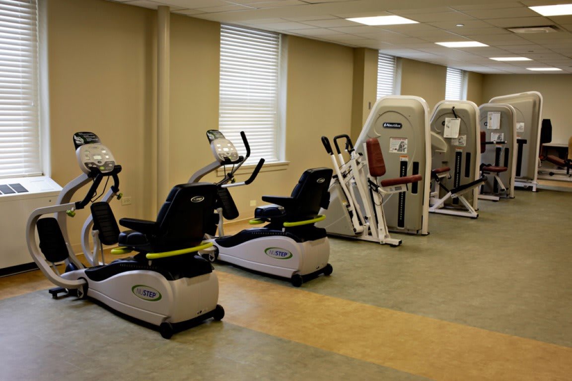 A gym with various exercise machines and fitness equipment.