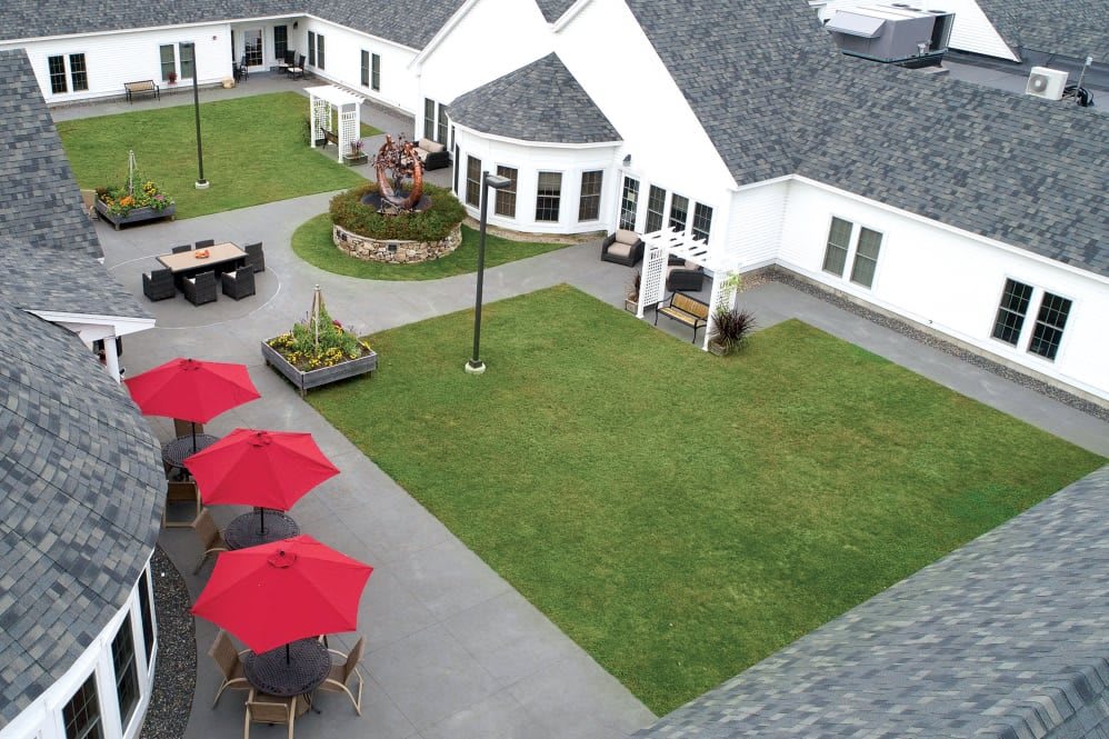Aerial view of a well-maintained courtyard with red umbrellas and outdoor seating.