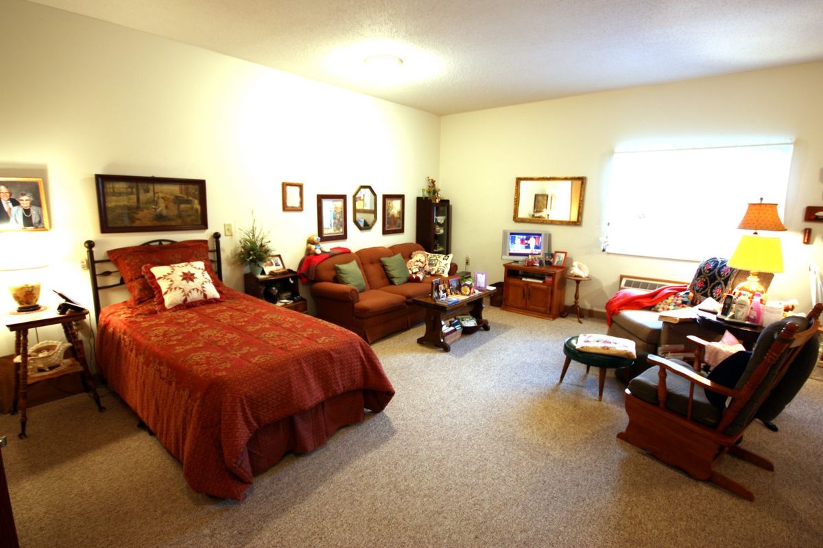 A cozy bedroom with a bed, sofa, and various decor elements.
