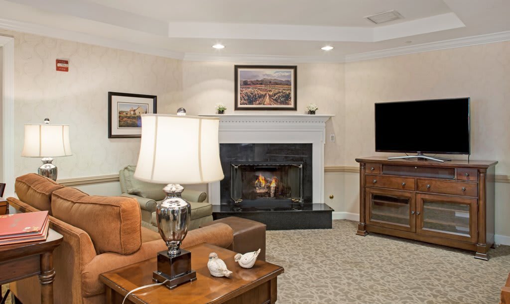 A cozy living room featuring a fireplace, comfortable seating, and modern decor.