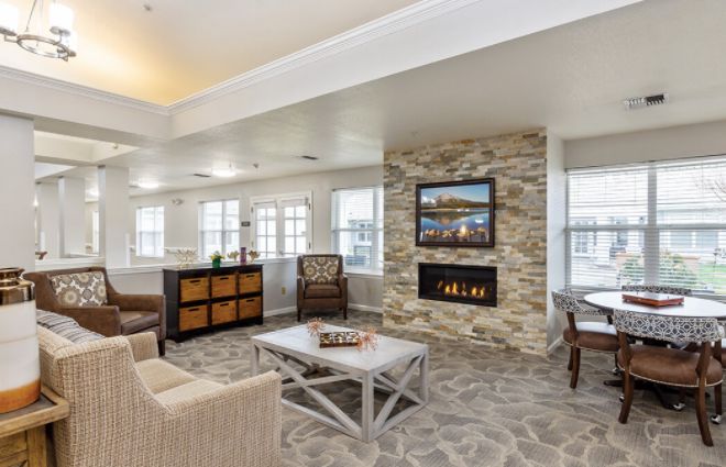 A modern living room featuring a stone fireplace and cozy seating.