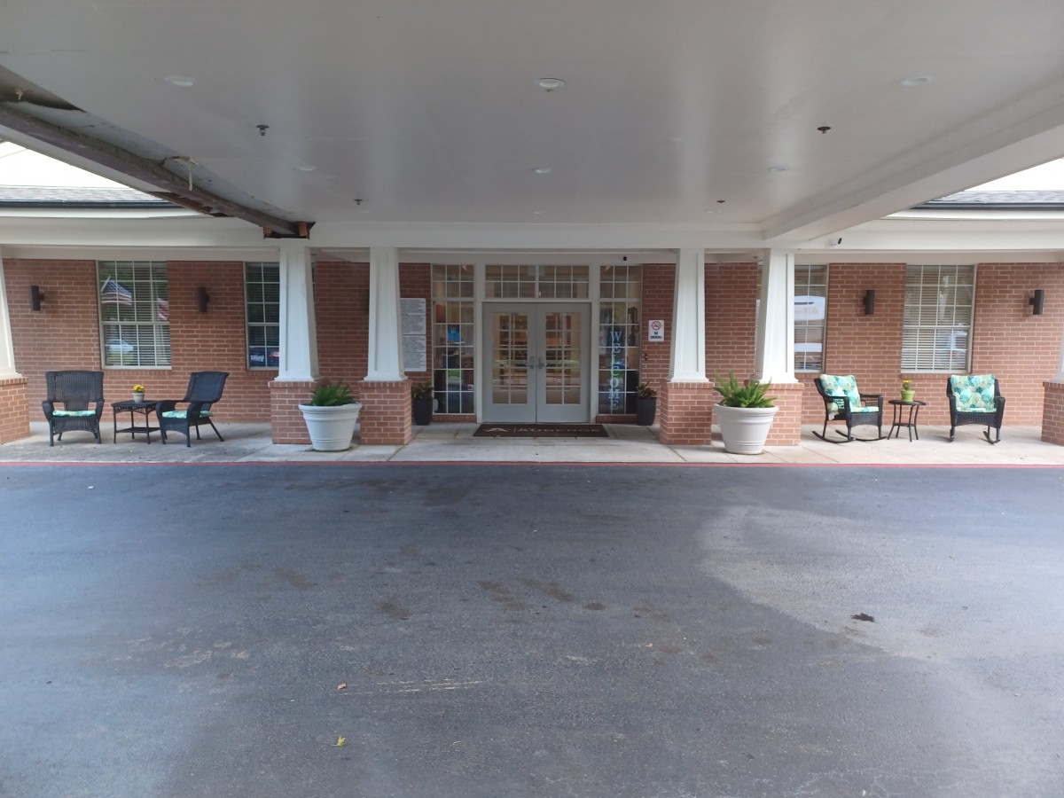 The entrance of a building with columns and seating areas.