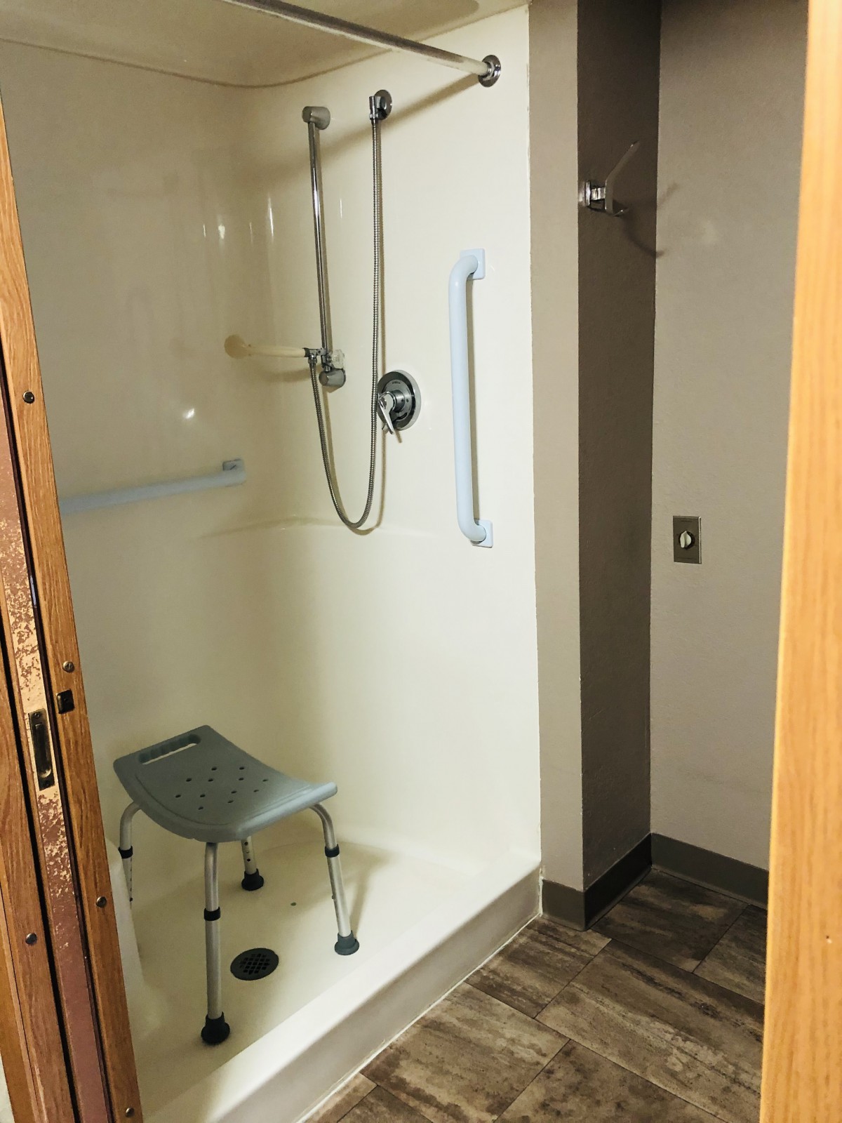 An accessible walk-in shower with a chair and grab bars for safety.