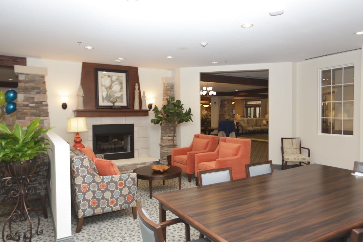 A cozy living space featuring a fireplace, comfortable chairs, and a stylish table.