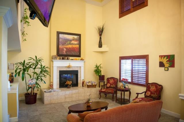 A cozy living room featuring a fireplace, artwork, and comfortable seating.