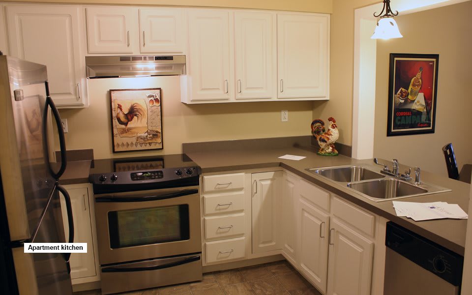 A modern kitchen with stainless steel appliances and white cabinets.