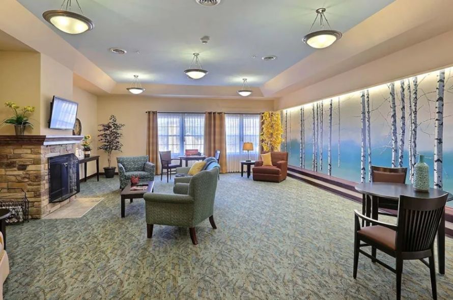 A spacious and well-lit living room with comfortable seating and large windows.