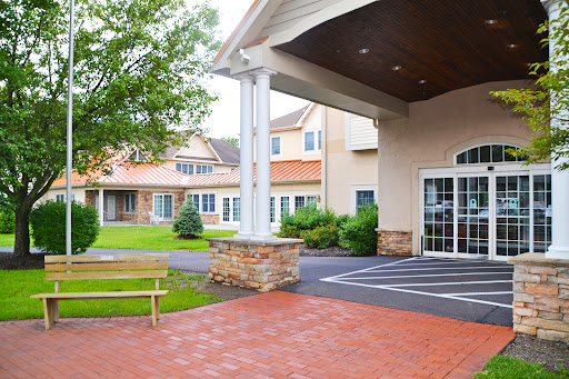 A welcoming entrance of a residential facility surrounded by greenery.