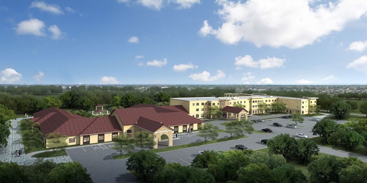An aerial view of a large building complex with a parking lot, surrounded by trees under a partly cloudy sky.