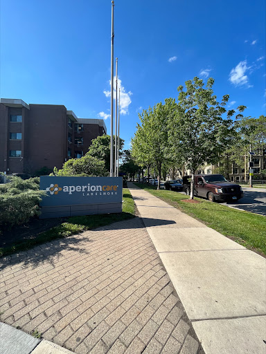 A view of the apartment complex entrance along a well-maintained sidewalk.