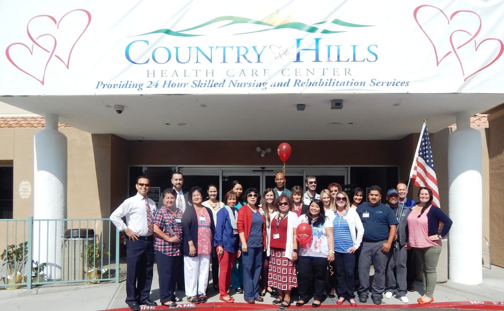 A group of people posing in front of Country Hills Healthcare Center.