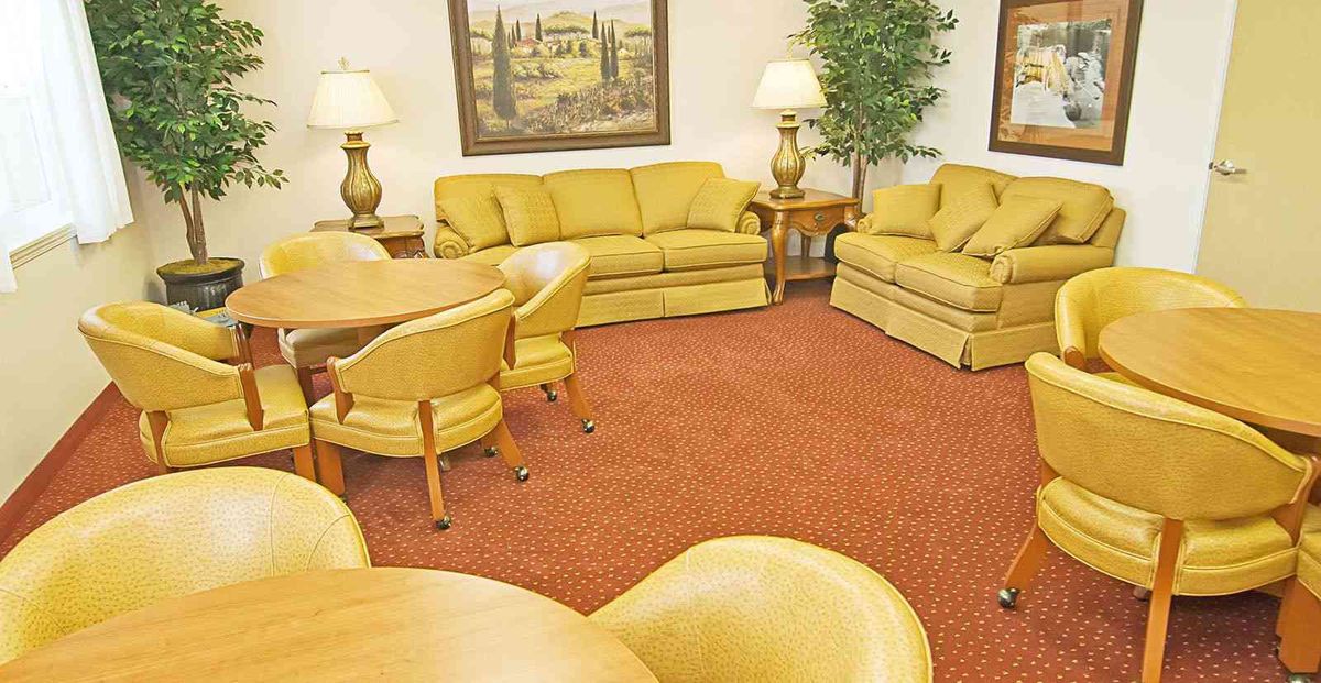 A cozy living room with yellow furniture and warm lighting.