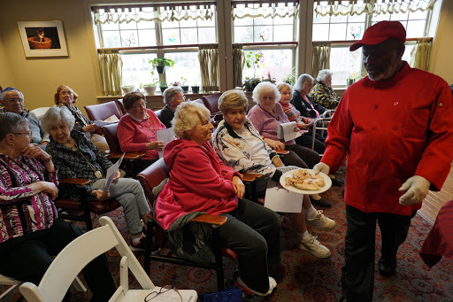 A lively gathering of seniors enjoying snacks and each other's company during a community event.