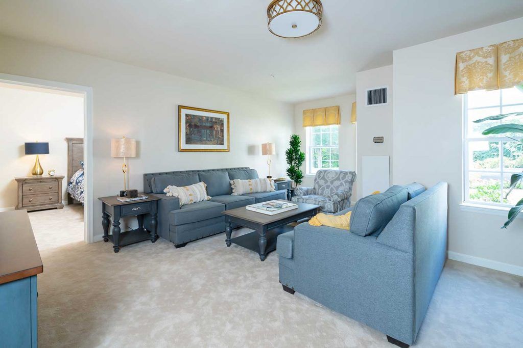 A modern living room with blue sofas, a coffee table, and elegant decor.
