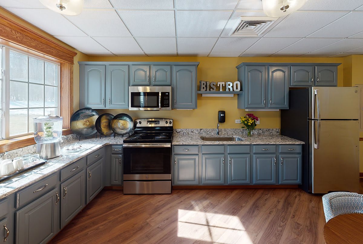 A cozy kitchen with blue cabinets and modern appliances.