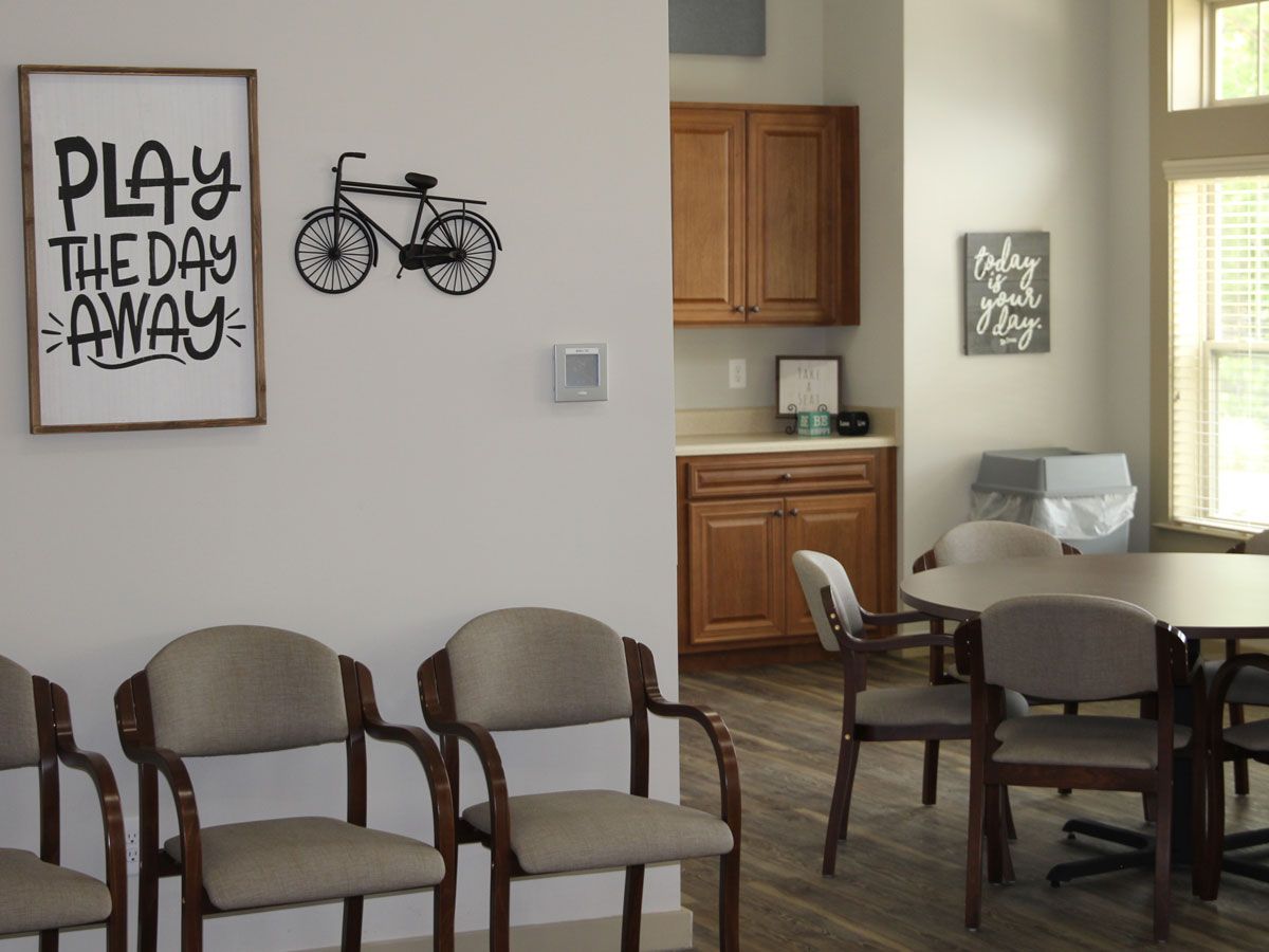 A cozy waiting room with chairs, a table, and bicycle-themed wall art.