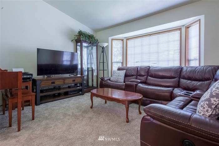 A cozy living room with a leather sofa, coffee table, and television.